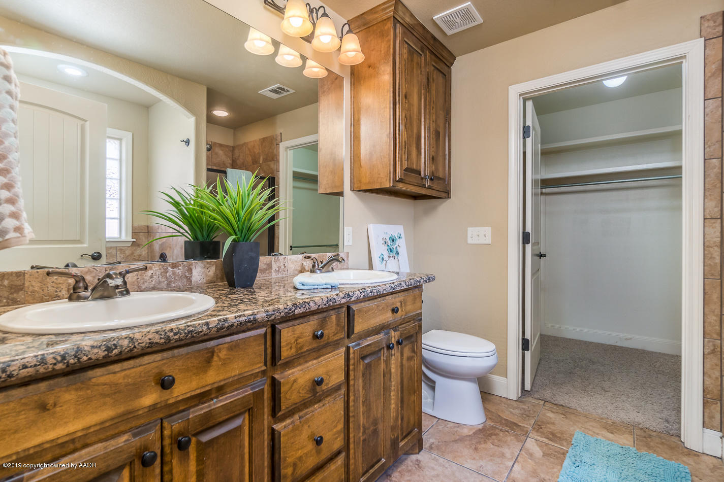 9203 Orry Avenue Amarillo, TX 79119 - Photo 12 of 22 a spacious bathroom with a granite countertop sink a toilet and a mirror