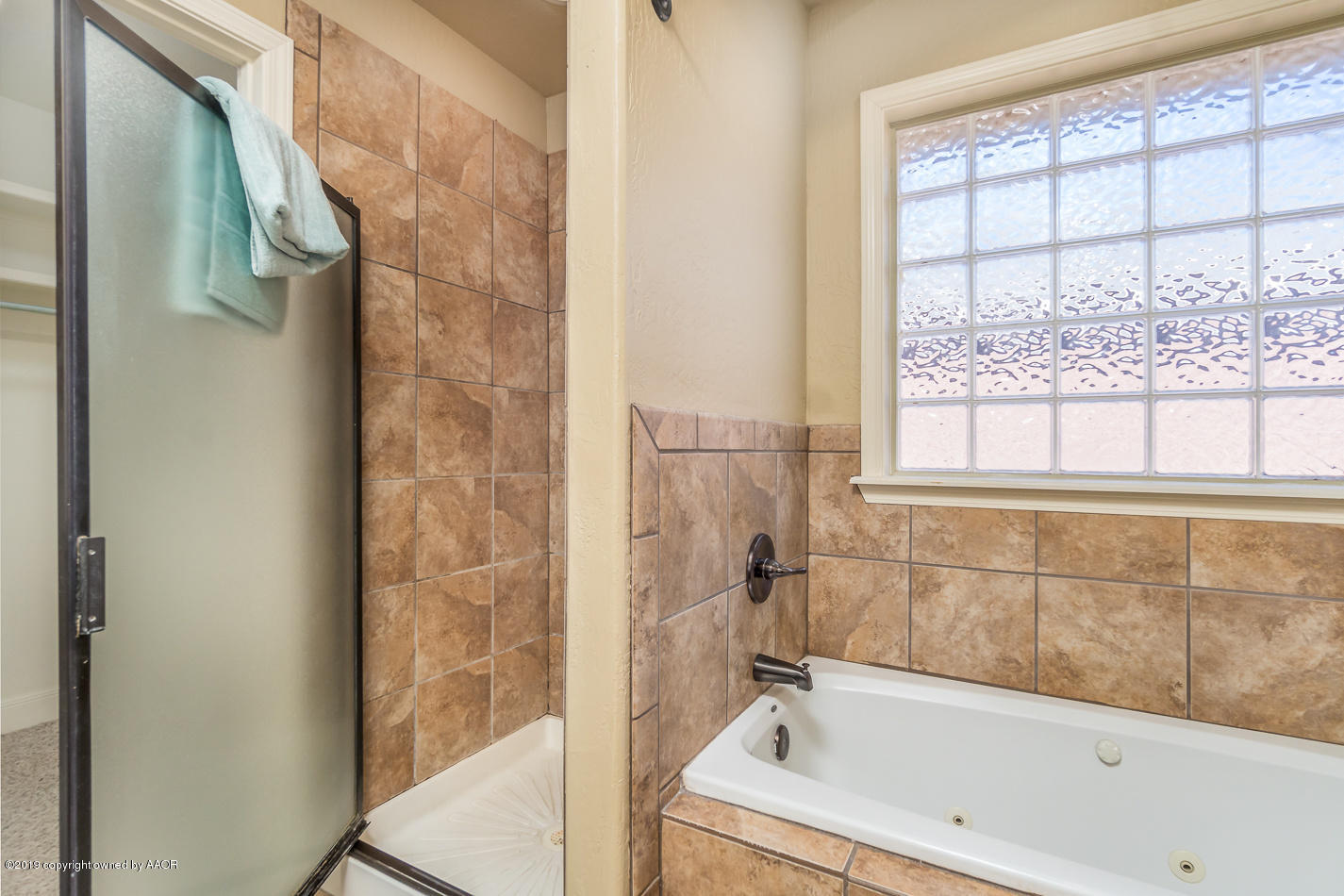 9203 Orry Avenue Amarillo, TX 79119 - Photo 13 of 22 a bathroom with a bathtub and window