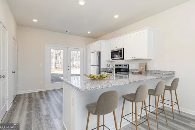 a kitchen with granite countertop counter space dining table and stainless steel appliances
