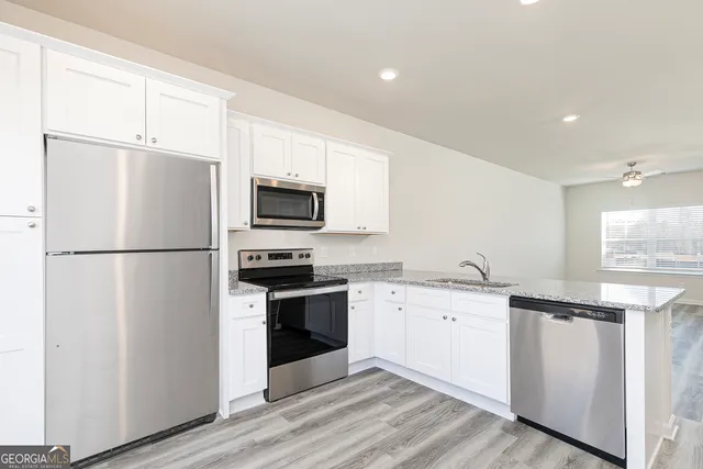 a kitchen with stainless steel appliances granite countertop a refrigerator stove a sink and a microwave