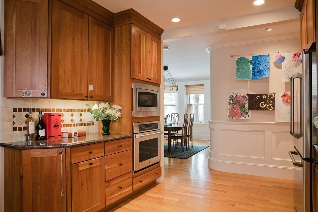 26 Hurlbut Street, Unit 2 Cambridge, MA 02138 - Photo 5 of 17 a kitchen with granite countertop wooden cabinets and white appliances