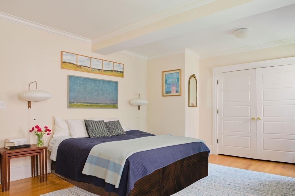 26 Hurlbut Street, Unit 2 Cambridge, MA 02138 - Photo 7 of 17 a bedroom with a bed and a chandelier