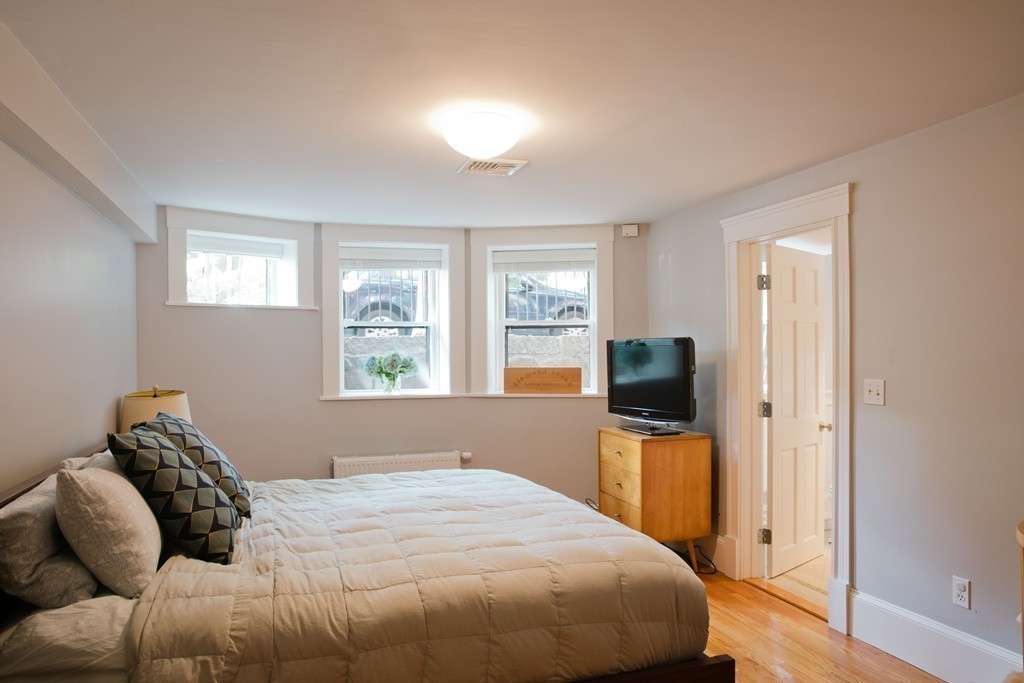 26 Hurlbut Street, Unit 2 Cambridge, MA 02138 - Photo 10 of 17 a bedroom with a bed flat screen tv and window
