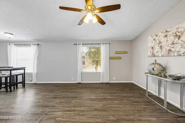 a view of a livingroom with a workspace wooden floor and a chandelier fan
