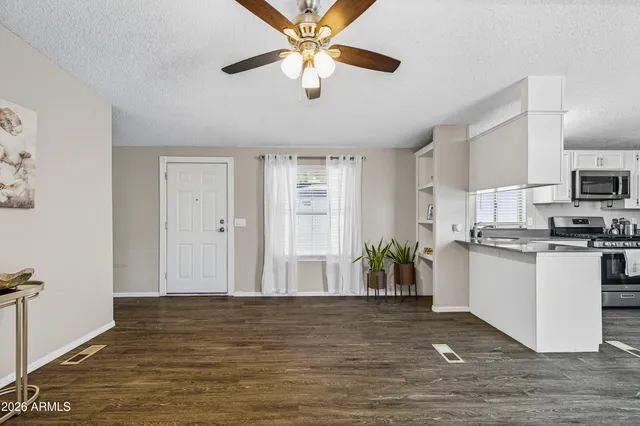 a view of a kitchen with kitchen island wooden floor center island and stainless steel appliances