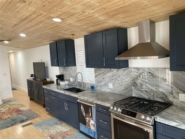 a kitchen with granite countertop a stove and a sink