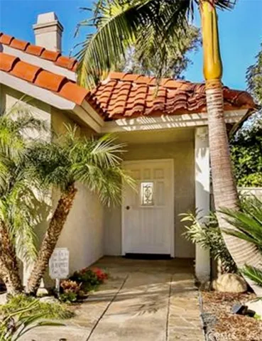 a view of a entryway door with potted plants
