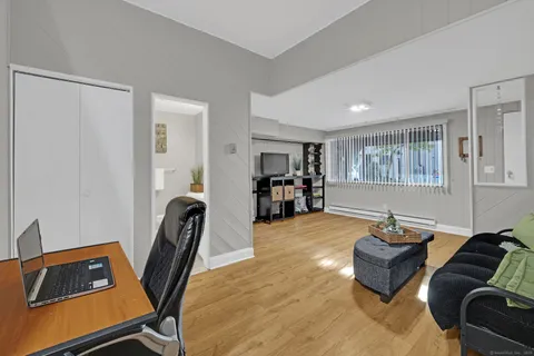 a living room with stainless steel appliances furniture and a kitchen view