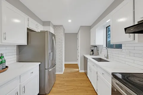 a kitchen with stainless steel appliances a refrigerator sink and cabinets