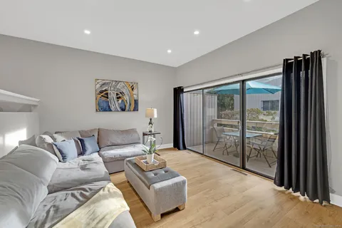 a living room with furniture a large window and a flat screen tv