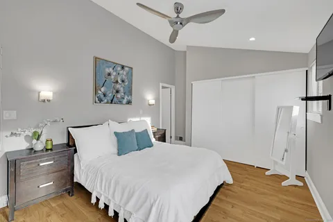 a bedroom with a bed and painting on the wall