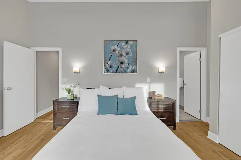 a bedroom with a bed and wooden floor