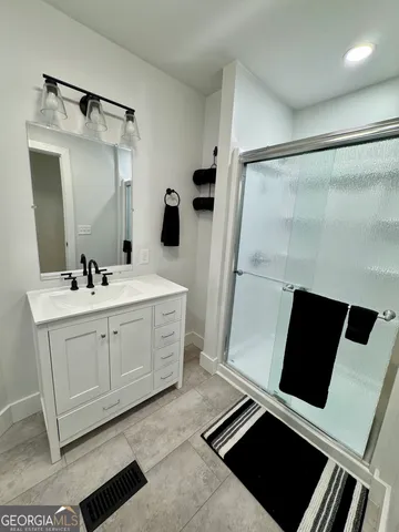 a spacious bathroom with a double vanity sink and mirror
