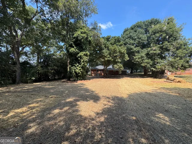 a view of house with yard and outdoor seating