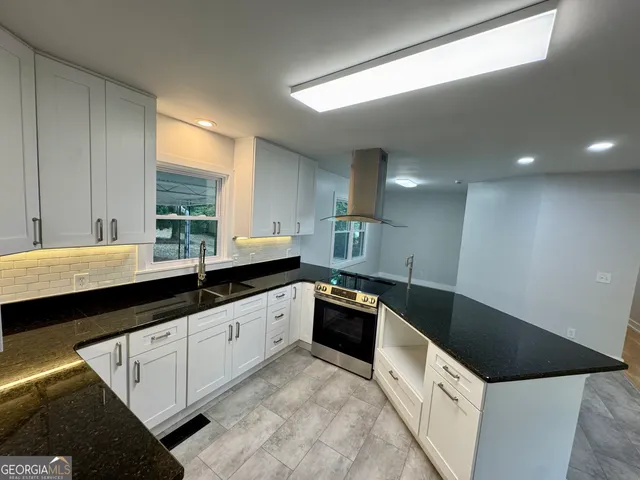 a kitchen with granite countertop a sink and cabinets