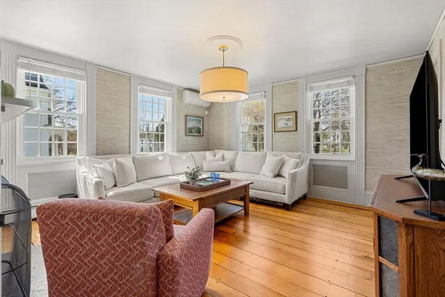 a living room with furniture a flat screen tv and a window