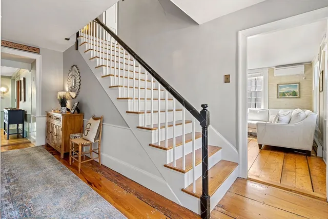 a view of an entryway with wooden floor and a livingroom