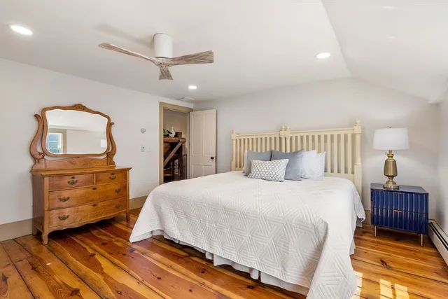 a bedroom with a bed and painting on the wall