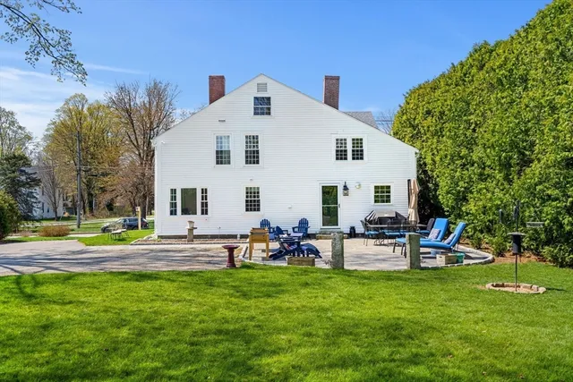a view of a house with backyard and sitting area