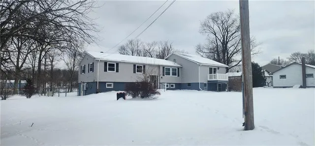 a view of a house with a yard covered in snow