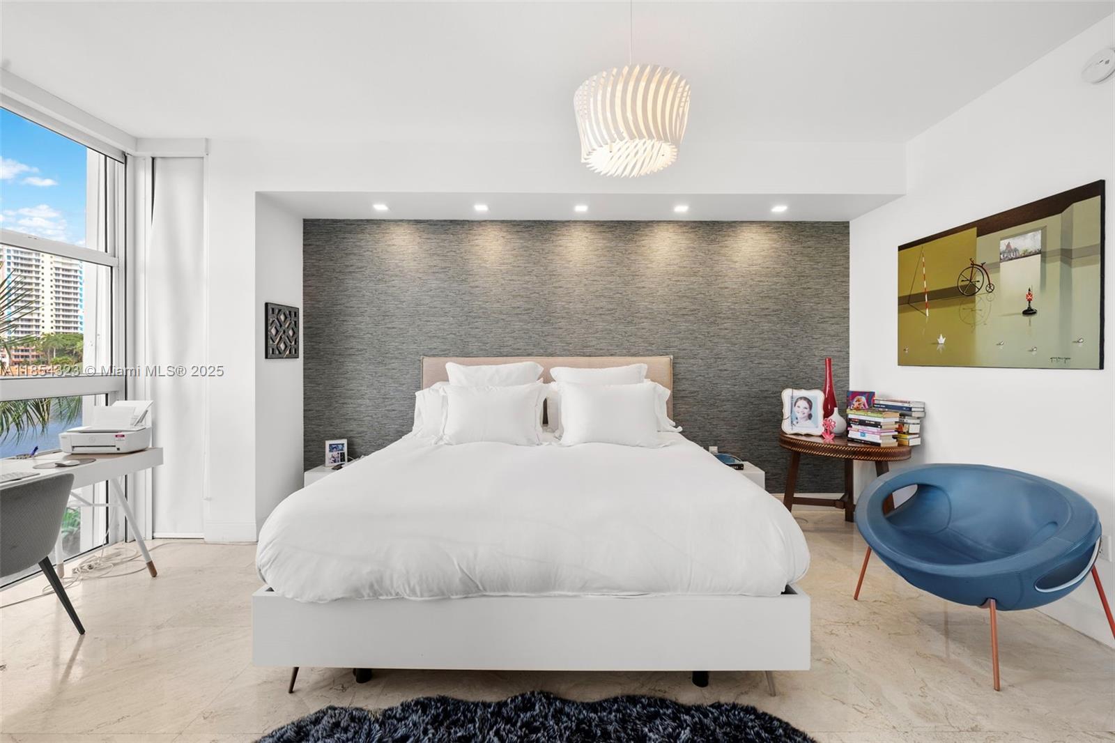 723 Crandon Boulevard, Unit 305 Key Biscayne, FL 33149 - Photo 11 of 29 a bedroom with a bed and a chandelier