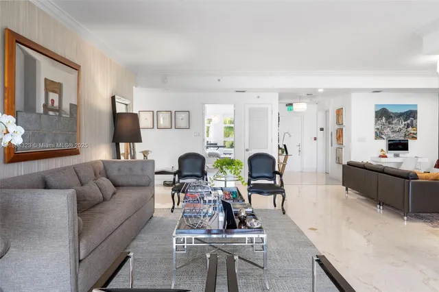 a living room with furniture potted plant and kitchen view