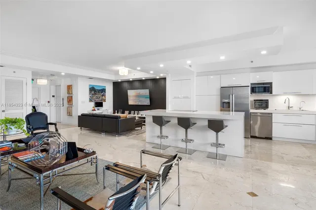a living room with furniture kitchen view and a flat screen tv