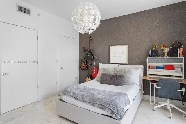 a bedroom with a bed and a chandelier