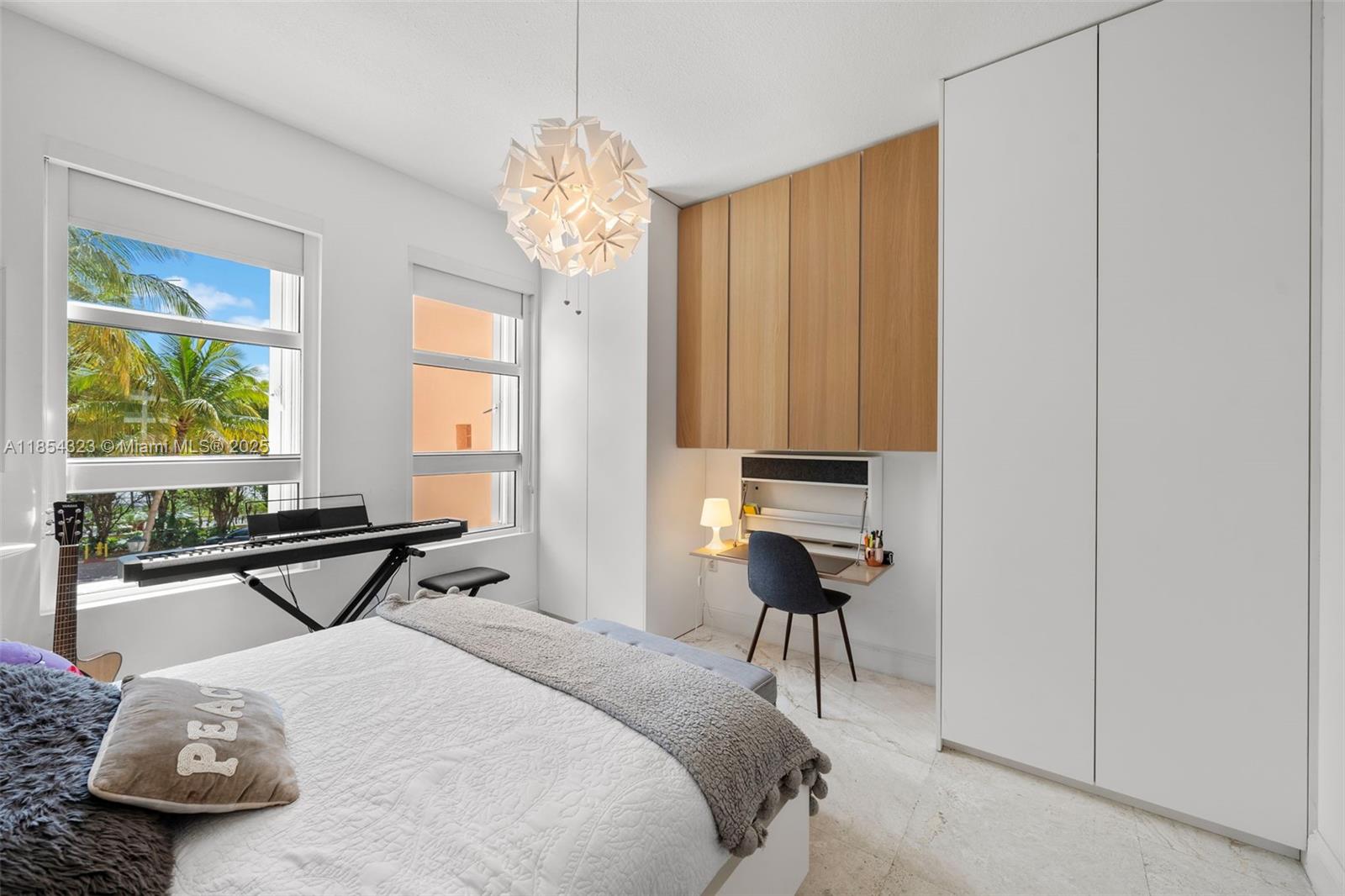 723 Crandon Boulevard, Unit 305 Key Biscayne, FL 33149 - Photo 25 of 29 a bedroom with a bed and a table in it