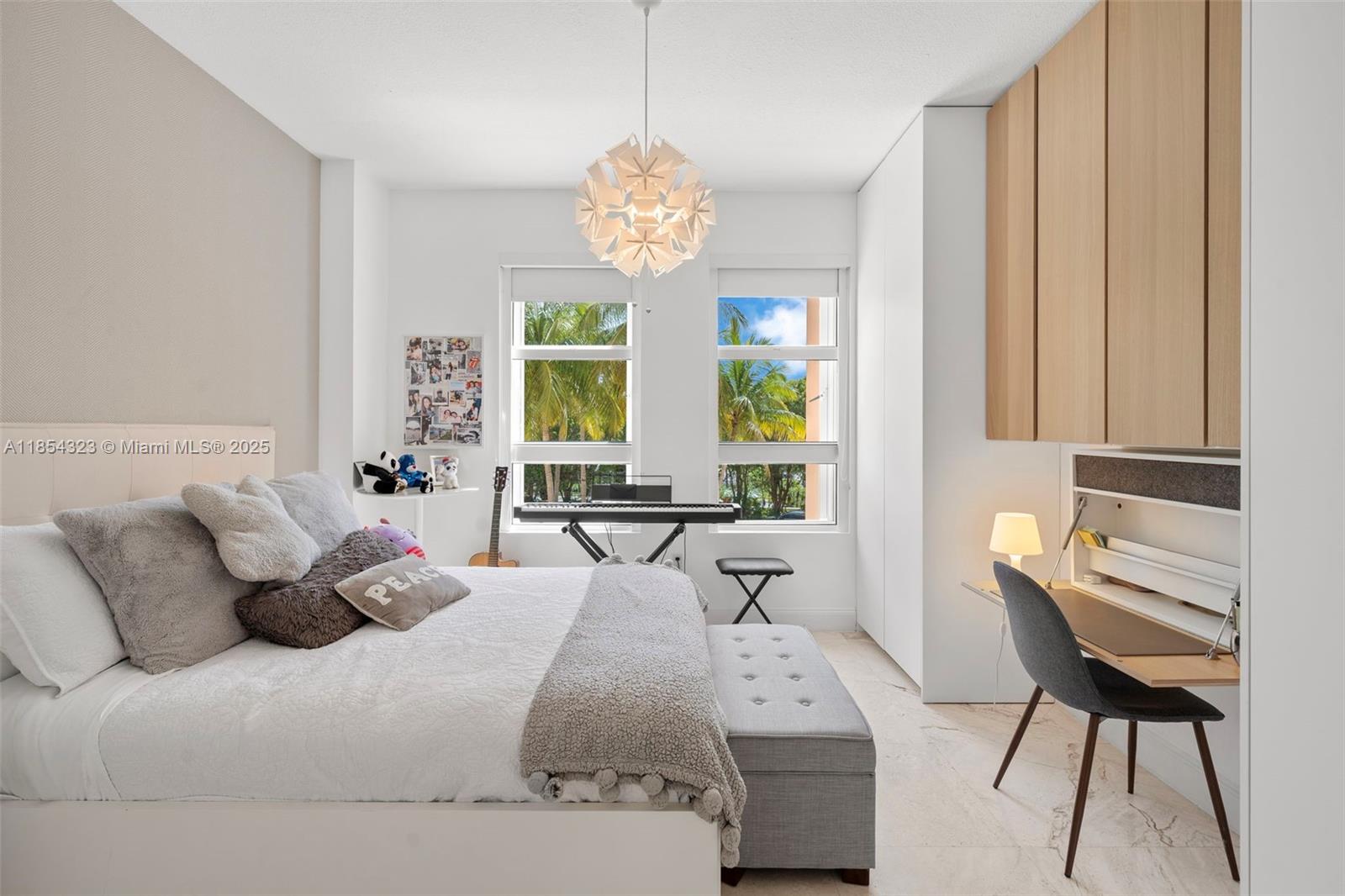 723 Crandon Boulevard, Unit 305 Key Biscayne, FL 33149 - Photo 26 of 29 a bedroom with a bed and a chandelier