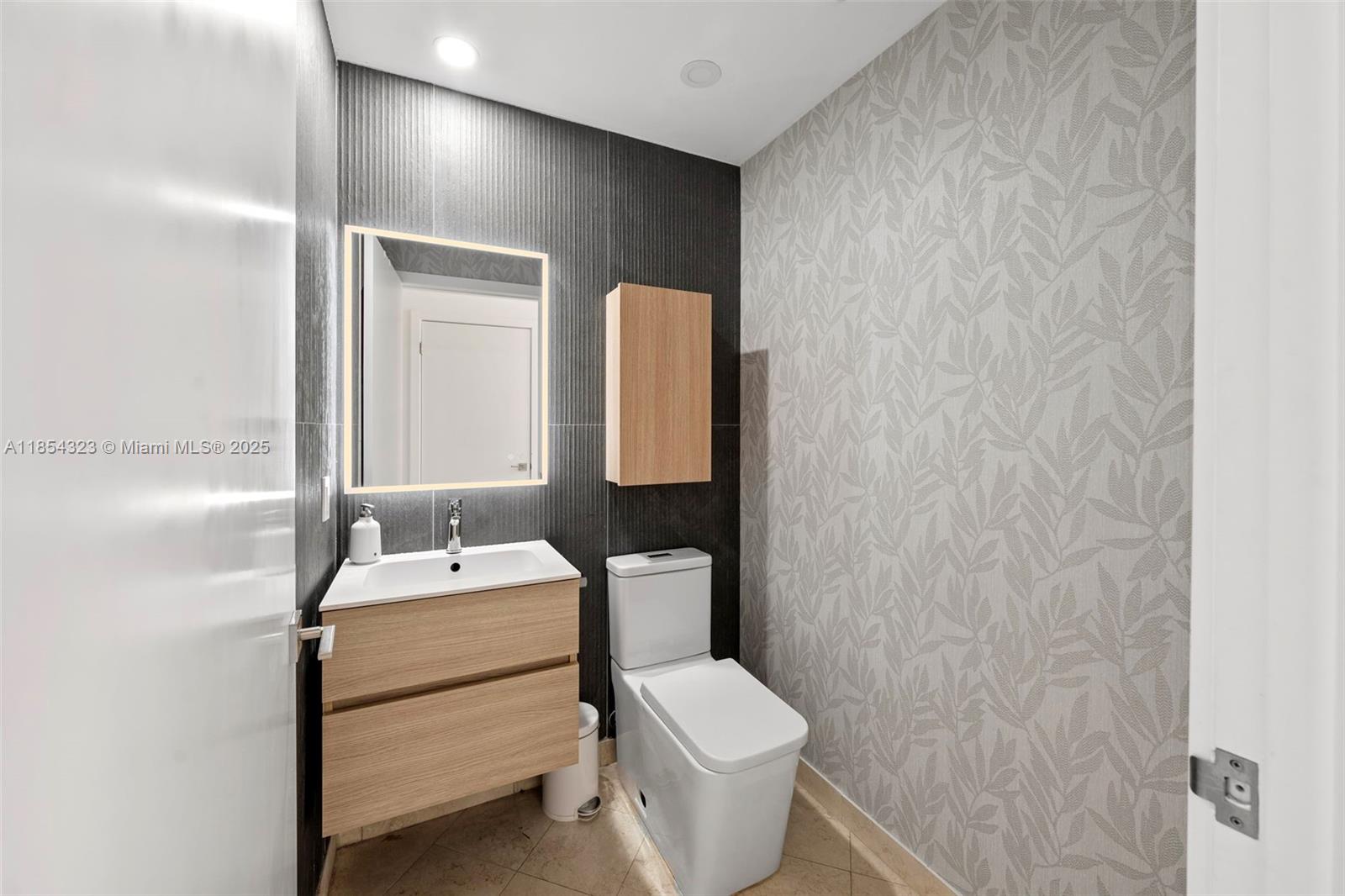 723 Crandon Boulevard, Unit 305 Key Biscayne, FL 33149 - Photo 28 of 29 a bathroom with a sink toilet and mirror