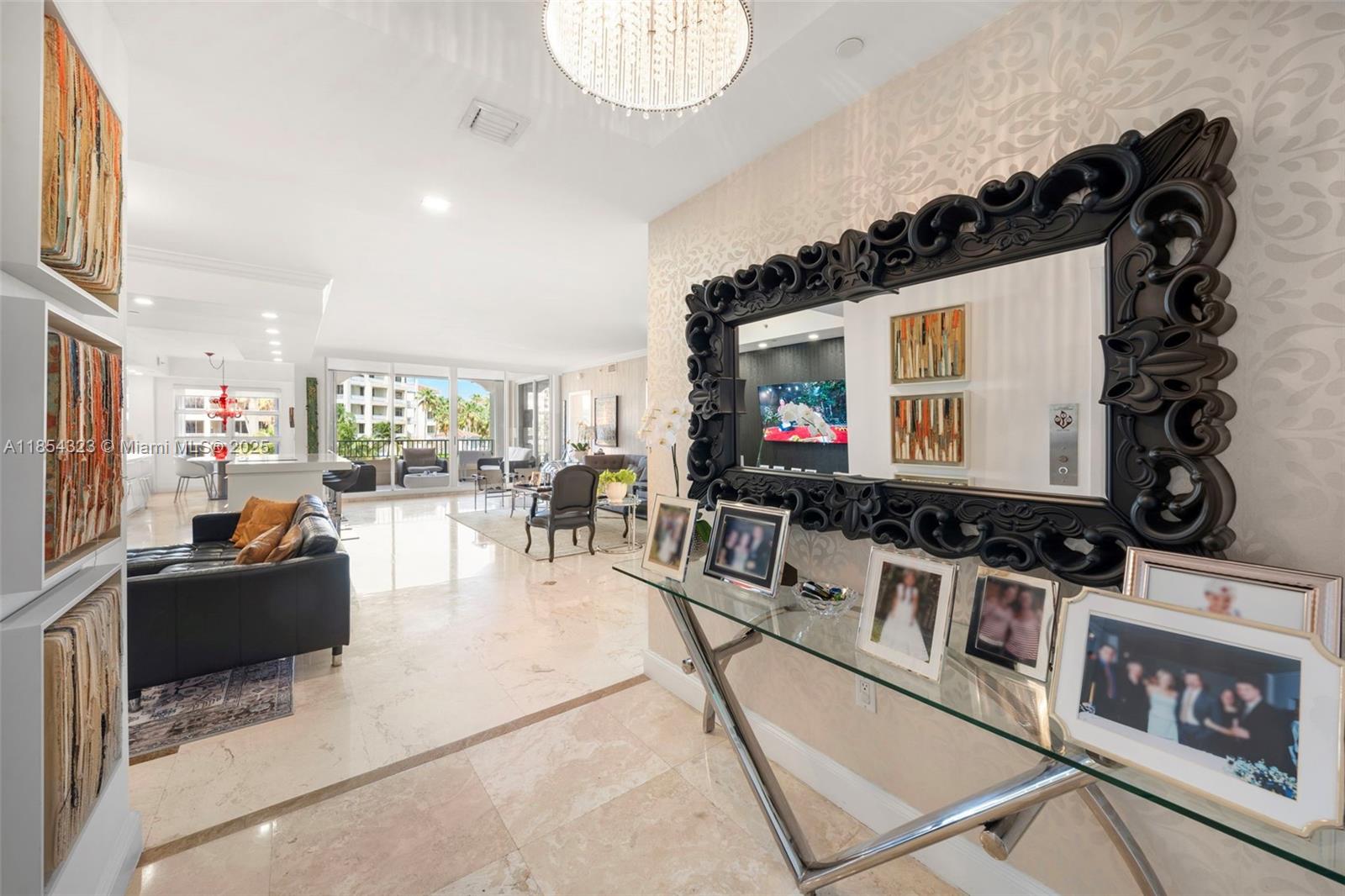 723 Crandon Boulevard, Unit 305 Key Biscayne, FL 33149 - Photo 4 of 29 a living room with furniture a flat screen tv and a large window