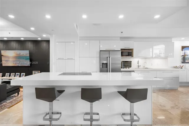 a kitchen with stainless steel appliances kitchen island granite countertop a stove a sink and a refrigerator