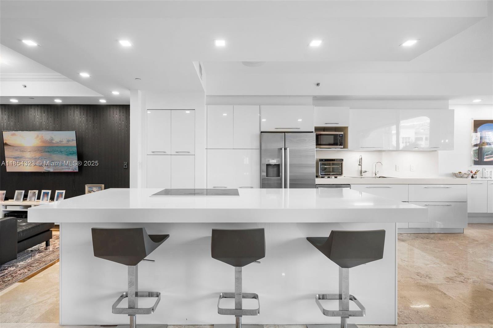 723 Crandon Boulevard, Unit 305 Key Biscayne, FL 33149 - Photo 7 of 29 a kitchen with stainless steel appliances kitchen island granite countertop a stove a sink and a refrigerator