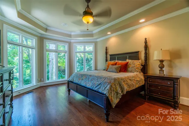 a bed sitting in a spacious bedroom next to a window