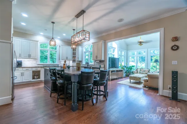 a view of a dining room and livingroom with furniture wooden floor a chandelier
