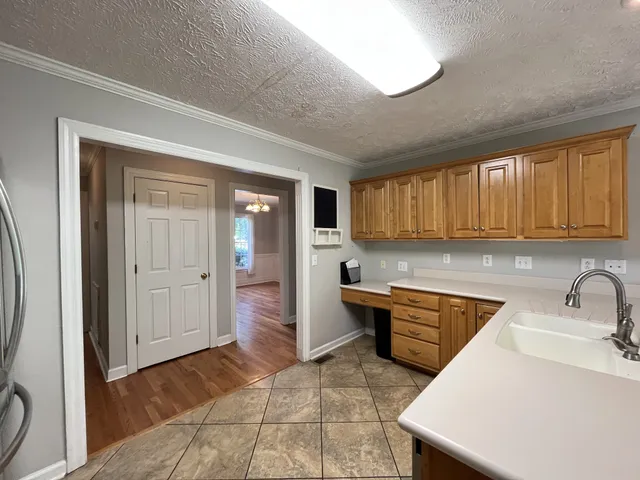 a kitchen that has a sink in it and wooden cabinets