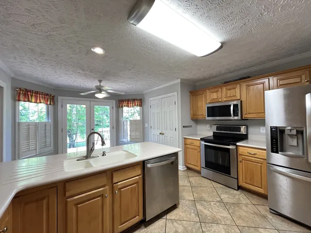 a kitchen with stainless steel appliances granite countertop a sink a stove and a refrigerator
