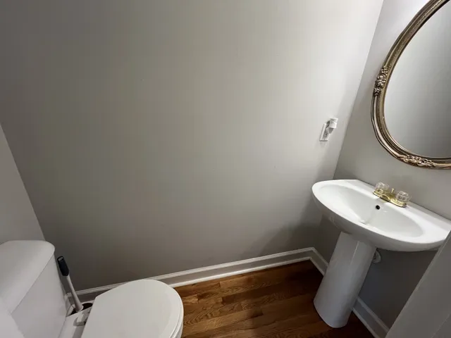 a bathroom with a toilet a sink and mirror