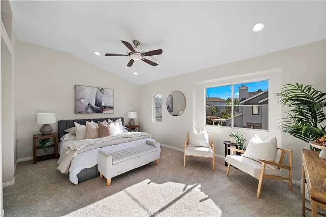 a spacious bedroom with a bed a couch and a potted plant