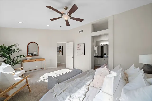 a bedroom with a large bed and a potted plant