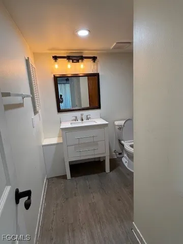 a bathroom with a toilet a sink and mirror