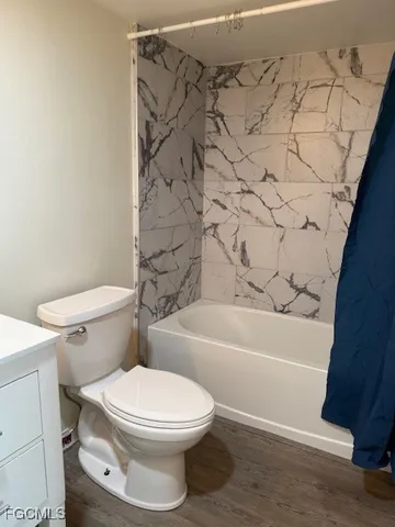 a white toilet sitting next to a bath tub and a shower