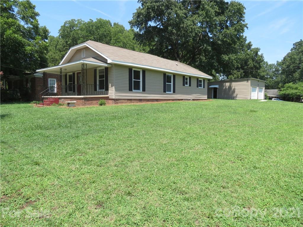 431 Union Cemetery Road Southwest Concord, NC 28027 - Photo 1 of 38 a front view of a house with a garden and trees