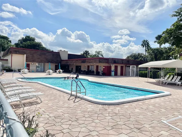 a view of a house with swimming pool and sitting area