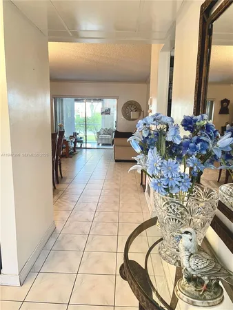 a living room with furniture a flat screen tv and a floor to ceiling window
