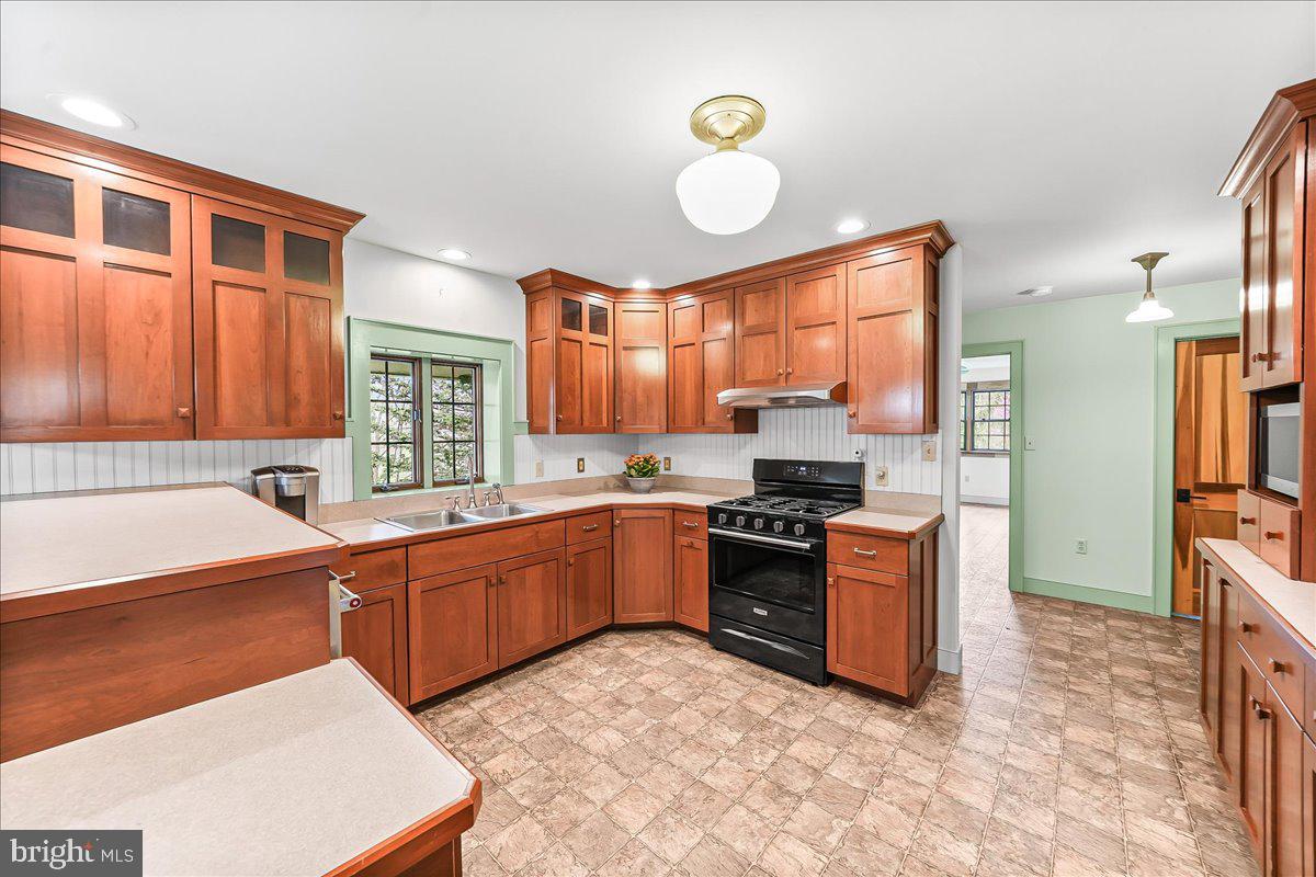 202 Creek Road Lincoln University, PA 19352 - Photo 8 of 36 a kitchen with stainless steel appliances granite countertop a stove top oven a sink dishwasher a dining table and chairs with wooden floor