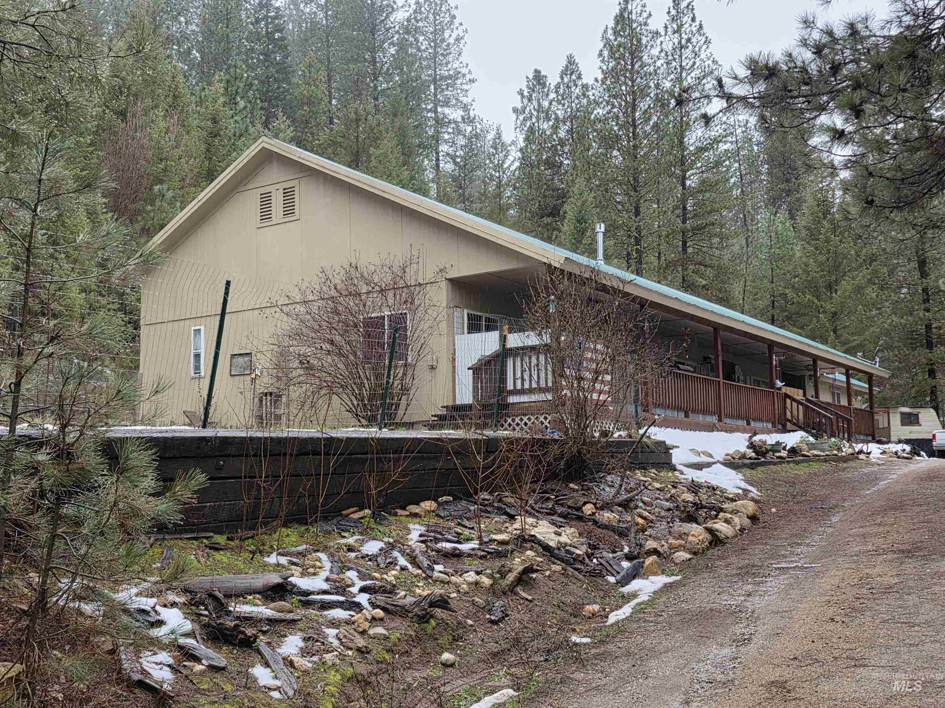 View of property exterior featuring a forest view and a porch