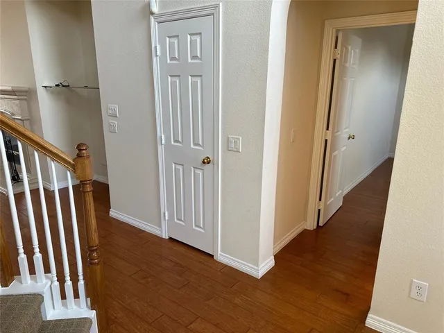 a view of a hallway with wooden floor and staircase