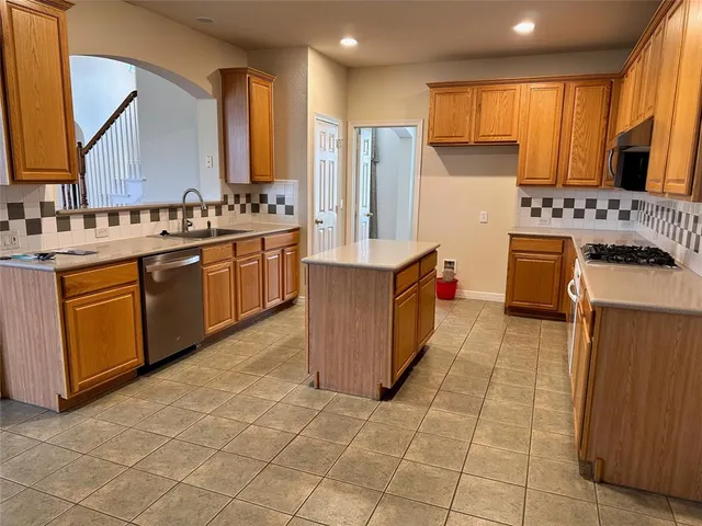 a kitchen with stainless steel appliances granite countertop a stove top oven sink and cabinets